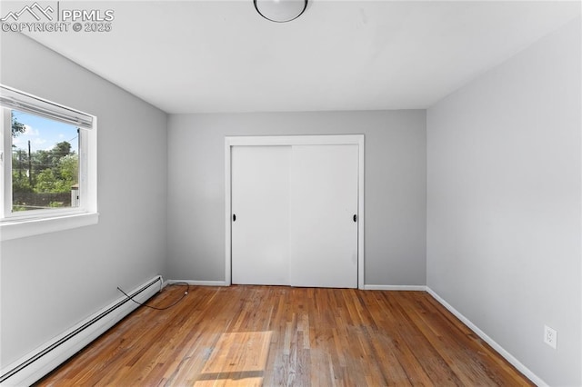 232 S Hancock Ave, Colorado Springs, CO 80903 - unfurnished bedroom featuring baseboard heating, wood-type flooring, and a closet