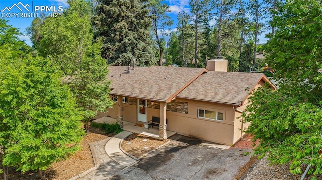 1105 Parkview Blvd, Colorado Springs, CO 80905 - view of front of property with roof with shingles, stucco siding, a chimney, and a patio area