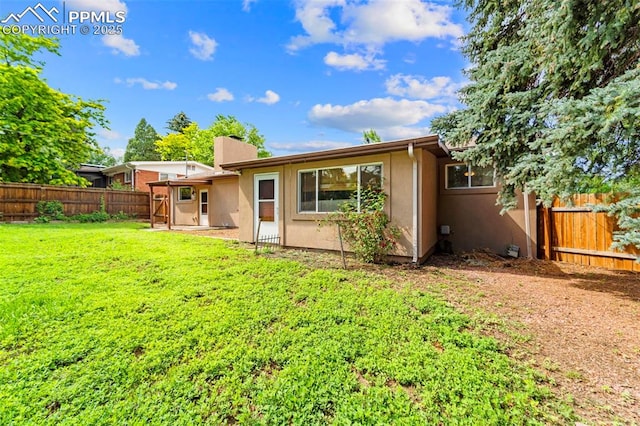 1105 Parkview Blvd, Colorado Springs, CO 80905 - back of property featuring a fenced backyard, stucco siding, and a chimney