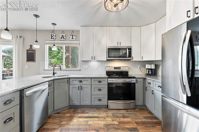 4914 Hawk Meadow Dr, Colorado Springs, CO 80916 - kitchen featuring appliances with stainless steel finishes, gray cabinets, dark wood-style floors, backsplash, and light stone counters