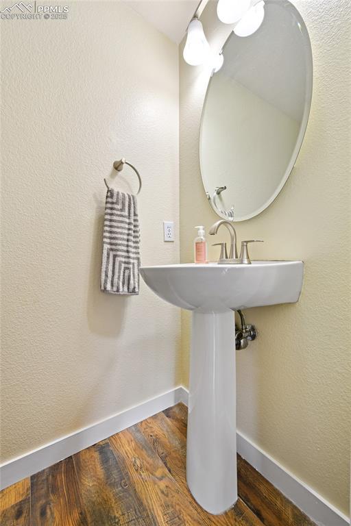 6290 Cording Ct, Colorado Springs, CO 80922 - bathroom with baseboards and wood finished floors