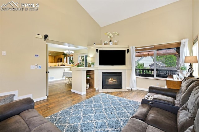 6290 Cording Ct, Colorado Springs, CO 80922 - living area featuring high vaulted ceiling, wood finished floors, a chandelier, and a tile fireplace