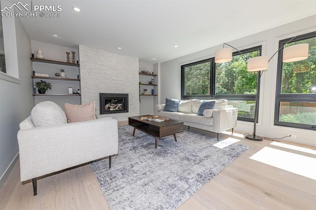 2510 Old Broadmoor Rd, Colorado Springs, CO 80906 - living area featuring wood finished floors, a stone fireplace, built in shelves, and recessed lighting