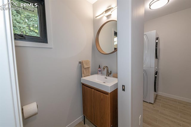 2510 Old Broadmoor Rd, Colorado Springs, CO 80906 - bathroom featuring stacked washer and clothes dryer, vanity, and wood finished floors