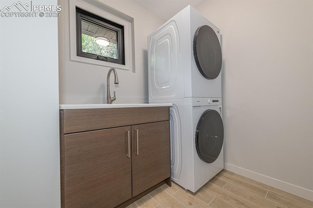 2510 Old Broadmoor Rd, Colorado Springs, CO 80906 - washroom featuring stacked washing machine and dryer, light wood-style floors, and cabinet space