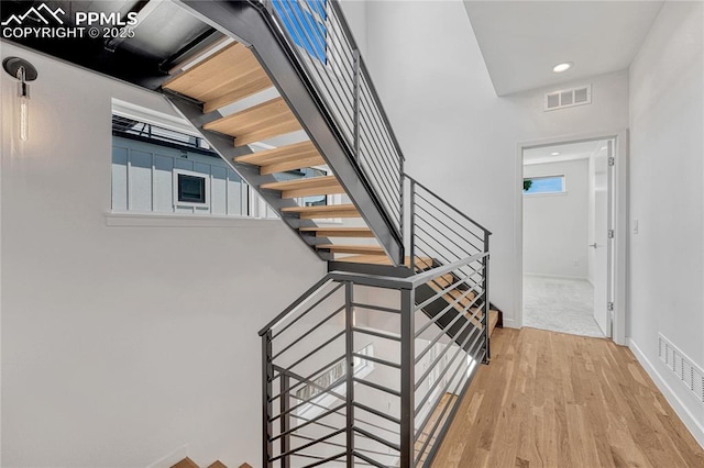 1231 Newton St, Denver, CO 80204 - stairs featuring wood finished floors, healthy amount of natural light, and recessed lighting