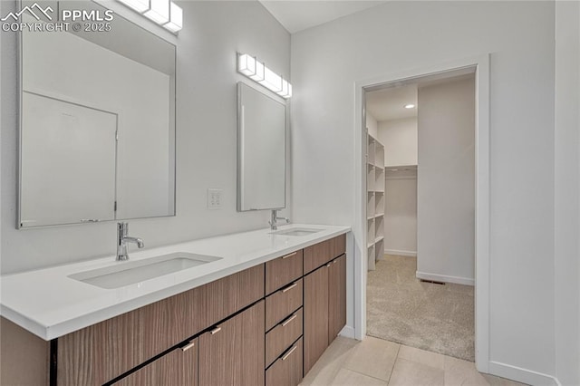 1231 Newton St, Denver, CO 80204 - bathroom featuring double vanity, tile patterned floors, and a walk in closet