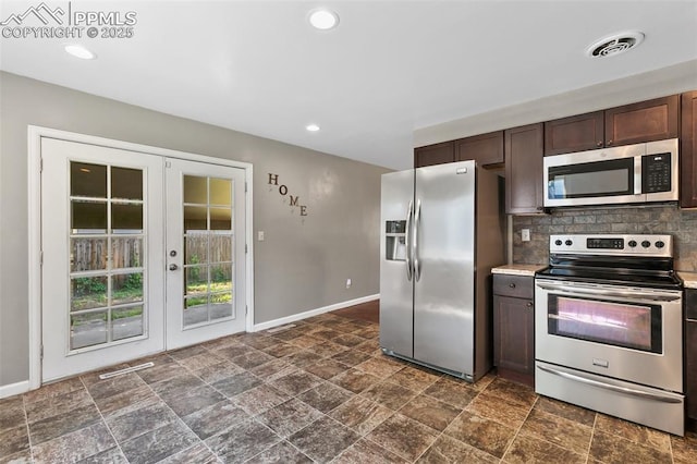 1443 Luna Dr, Fountain, CO 80817 - kitchen featuring appliances with stainless steel finishes, french doors, dark stone finish flooring, dark brown cabinetry, and tasteful backsplash
