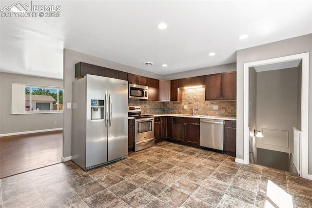 1443 Luna Dr, Fountain, CO 80817 - kitchen featuring appliances with stainless steel finishes, light countertops, decorative backsplash, dark brown cabinetry, and recessed lighting