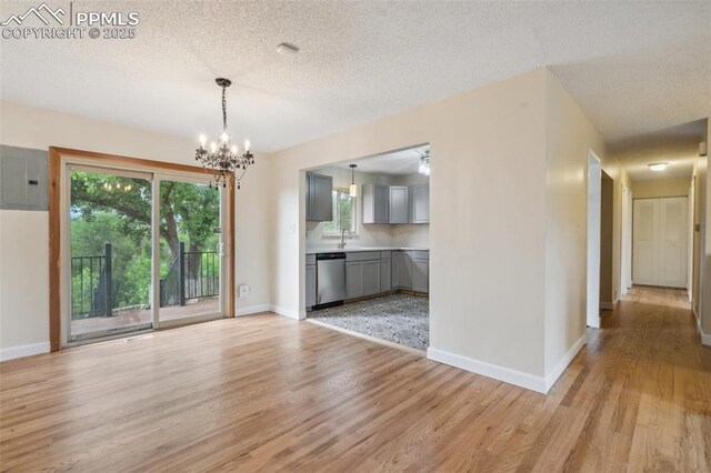 7030 Metropolitan St, Colorado Springs, CO 80911 - unfurnished dining area with electric panel, light wood-style floors, a chandelier, and a textured ceiling