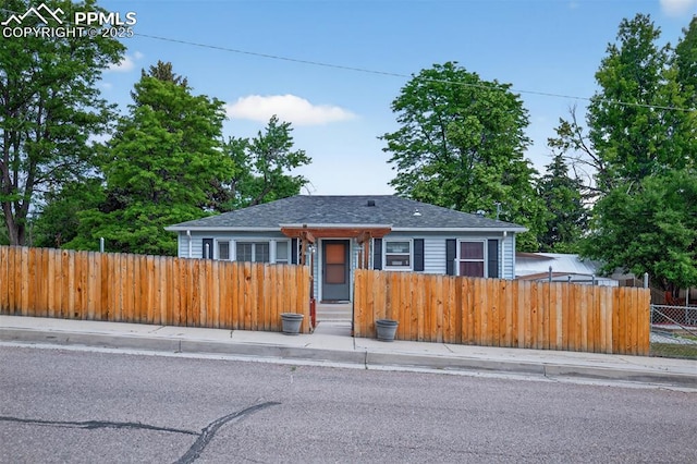 822 W Monroe St, Colorado Springs, CO 80907 - bungalow-style home with a fenced front yard and roof with shingles