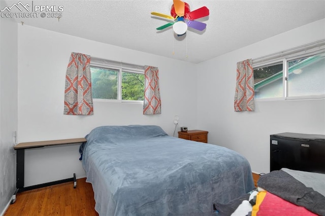 822 W Monroe St, Colorado Springs, CO 80907 - bedroom featuring wood finished floors, fridge, a textured ceiling, and ceiling fan