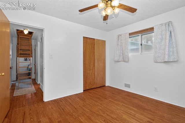 822 W Monroe St, Colorado Springs, CO 80907 - unfurnished bedroom with wood finished floors, a closet, ceiling fan, and a textured ceiling
