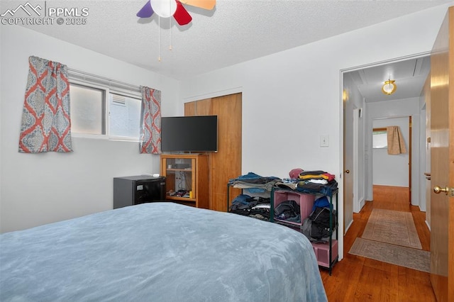 822 W Monroe St, Colorado Springs, CO 80907 - bedroom featuring attic access, wood finished floors, a textured ceiling, and a ceiling fan
