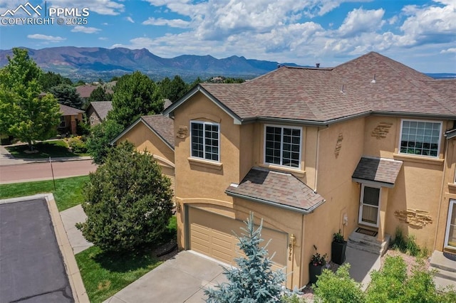 5775 Sonnet Hts, Colorado Springs, CO 80918 - view of front of home with stucco siding, a garage, a shingled roof, and concrete driveway