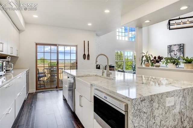 5775 Sonnet Hts, Colorado Springs, CO 80918 - kitchen featuring stainless steel appliances, recessed lighting, white cabinets, dark wood-style flooring, and a center island with sink