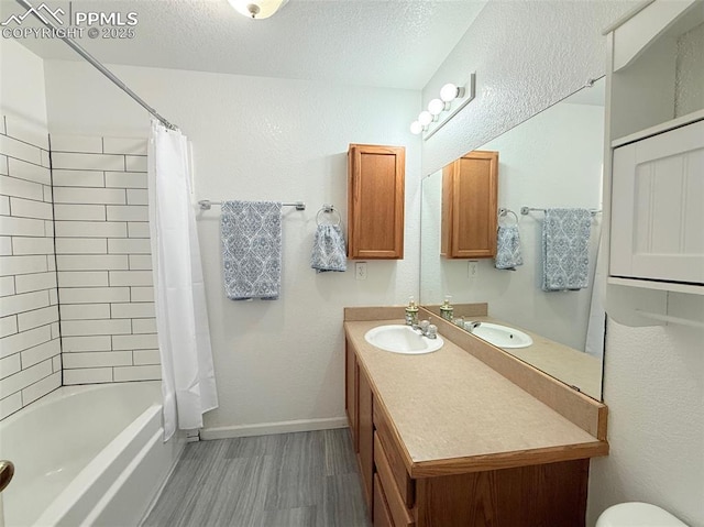 2160 Ance St, Strasburg, CO 80136 - full bathroom featuring wood finished floors, vanity, shower / tub combo with curtain, and a textured ceiling
