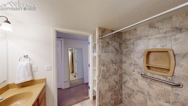 2160 Ance St, Strasburg, CO 80136 - bathroom with vanity, a tile shower, and a textured ceiling