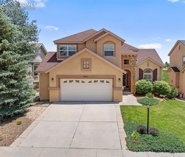 9891 Red Sage Dr, Colorado Springs, CO 80920 - traditional-style home with stucco siding, driveway, a front yard, an attached garage, and roof with shingles