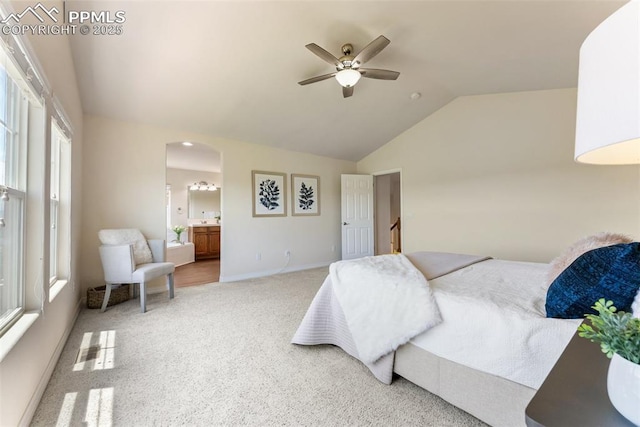 9891 Red Sage Dr, Colorado Springs, CO 80920 - bedroom featuring arched walkways, carpet flooring, vaulted ceiling, multiple windows, and ensuite bath