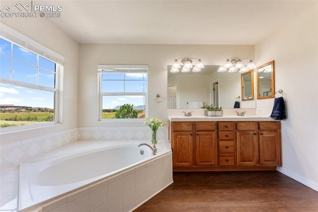 9891 Red Sage Dr, Colorado Springs, CO 80920 - bathroom with double vanity, a garden tub, and wood finished floors