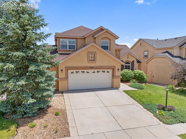 9891 Red Sage Dr, Colorado Springs, CO 80920 - view of front of property featuring stucco siding, driveway, a garage, and a front yard
