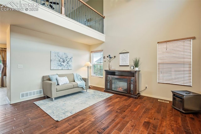 6372 Shooting Iron Way, Colorado Springs, CO 80923 - living area with a glass covered fireplace, wood finished floors, and a high ceiling