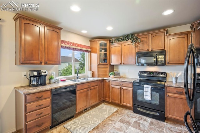 6372 Shooting Iron Way, Colorado Springs, CO 80923 - kitchen featuring black appliances, recessed lighting, glass insert cabinets, brown cabinetry, and light stone counters