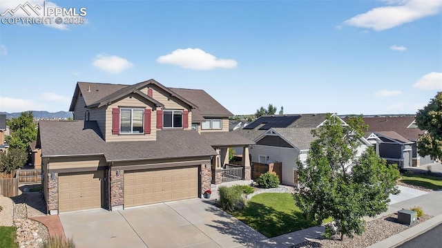 6372 Shooting Iron Way, Colorado Springs, CO 80923 - craftsman-style home with stone siding, a garage, concrete driveway, and a shingled roof
