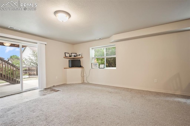 6372 Shooting Iron Way, Colorado Springs, CO 80923 - spare room featuring carpet, a textured ceiling, and stairway