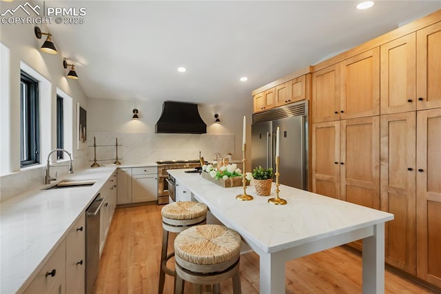 1320 Spring Valley Dr, Colorado Springs, CO 80921 - kitchen featuring ventilation hood, premium appliances, recessed lighting, a kitchen island, and light wood-type flooring