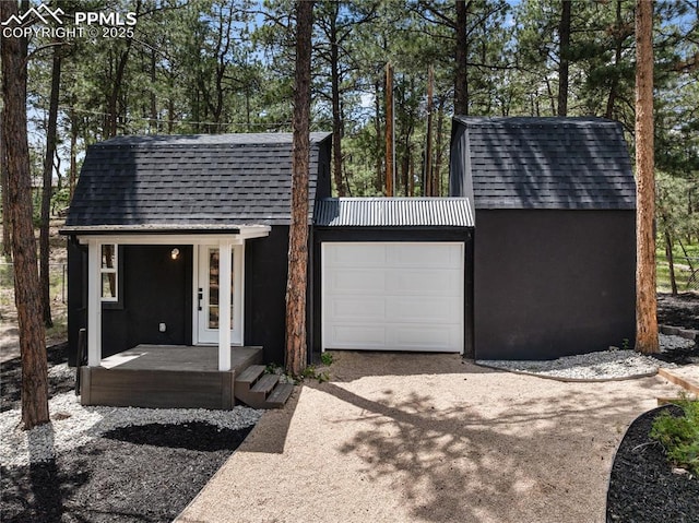 1320 Spring Valley Dr, Colorado Springs, CO 80921 - garage featuring driveway and view of scattered trees