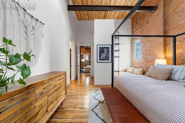 423 W 4th St, Pueblo, CO 81003 - bedroom with a high ceiling, light wood-style floors, brick wall, and a wood ceiling with exposed beams