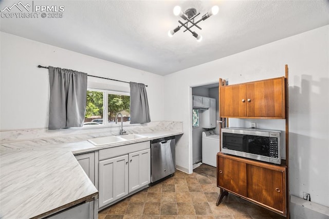 802 Alexander Rd, Colorado Springs, CO 80909 - kitchen with appliances with stainless steel finishes, washer / dryer, light countertops, and stone finish flooring
