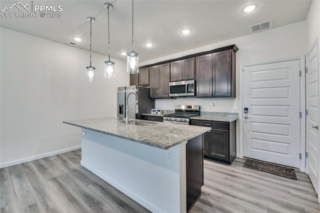 1608 Rose Quartz Hts, Colorado Springs, CO 80908 - kitchen featuring stainless steel appliances, dark brown cabinetry, an island with sink, light wood-type flooring, and recessed lighting