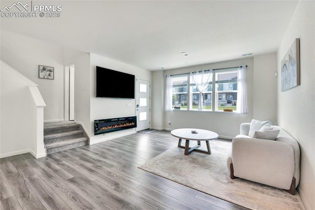 1608 Rose Quartz Hts, Colorado Springs, CO 80908 - living room featuring stairway, wood finished floors, and a glass covered fireplace