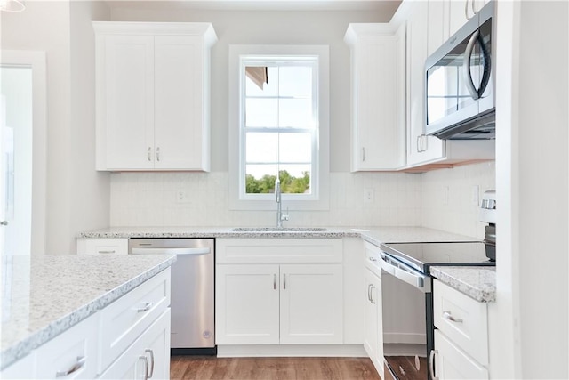 100 Hunters Way, Opelika, AL 36801 - kitchen with stainless steel appliances, a sink, white cabinetry, and backsplash
