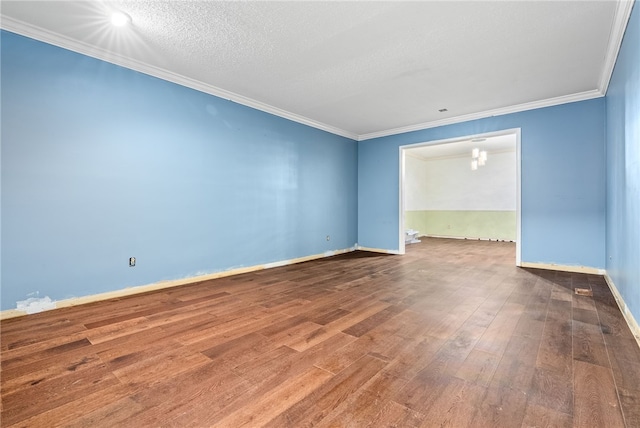 empty room featuring crown molding, a textured ceiling, and hardwood / wood-style flooring