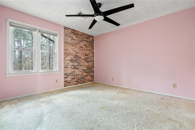 unfurnished room featuring ceiling fan, carpet, brick wall, and a textured ceiling