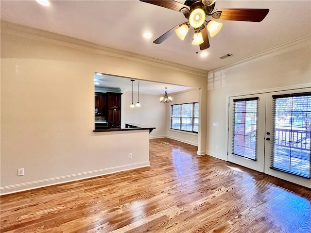 1807 Parsons Cir, Auburn, AL 36830 - unfurnished living room featuring ceiling fan with notable chandelier, light wood-type flooring, ornamental molding, and french doors
