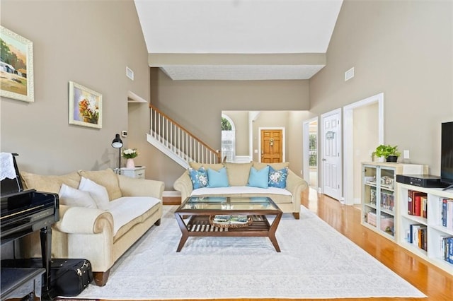 2260 Core Dr, Auburn, AL 36830 - living area with wood finished floors, stairway, and high vaulted ceiling