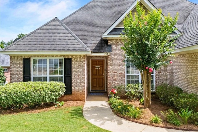 2260 Core Dr, Auburn, AL 36830 - property entrance featuring brick siding, roof with shingles, and a yard