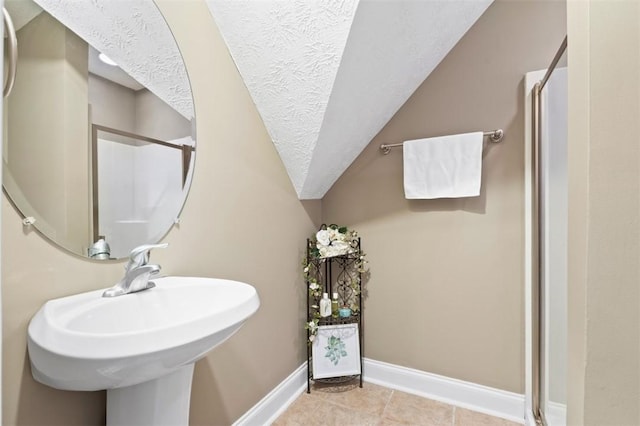 2260 Core Dr, Auburn, AL 36830 - bathroom featuring a shower stall, lofted ceiling, a textured ceiling, and tile patterned flooring