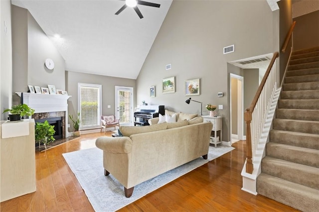 2260 Core Dr, Auburn, AL 36830 - living room featuring high vaulted ceiling, stairway, a fireplace, wood finished floors, and a ceiling fan