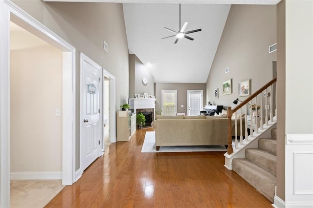 2260 Core Dr, Auburn, AL 36830 - living area featuring high vaulted ceiling, stairs, ceiling fan, a fireplace, and wood finished floors