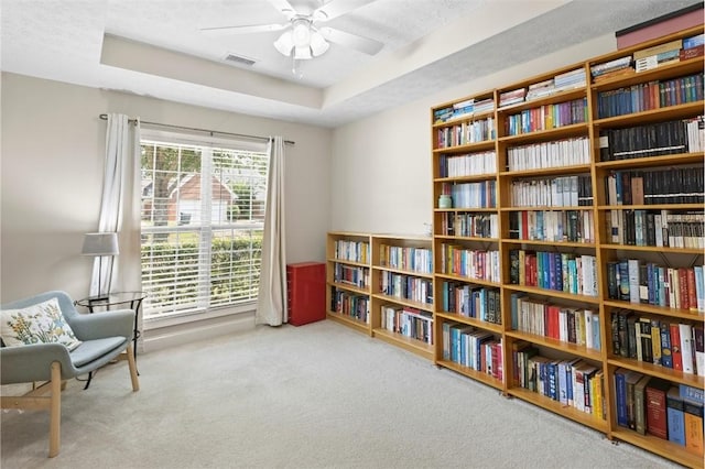 2260 Core Dr, Auburn, AL 36830 - sitting room featuring a tray ceiling, carpet, ceiling fan, and wall of books