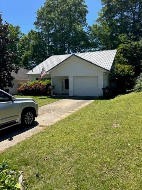 view of side of property with a yard, driveway, and metal roof