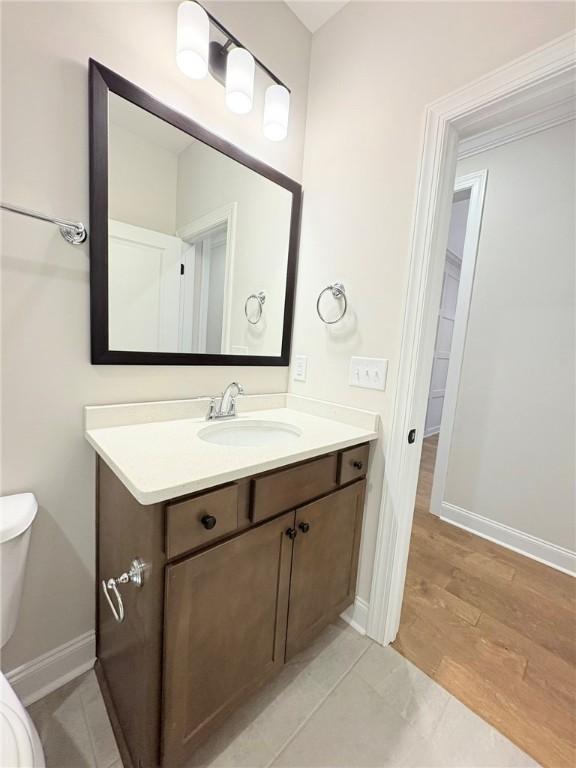 bathroom featuring vanity, toilet, and hardwood / wood-style floors