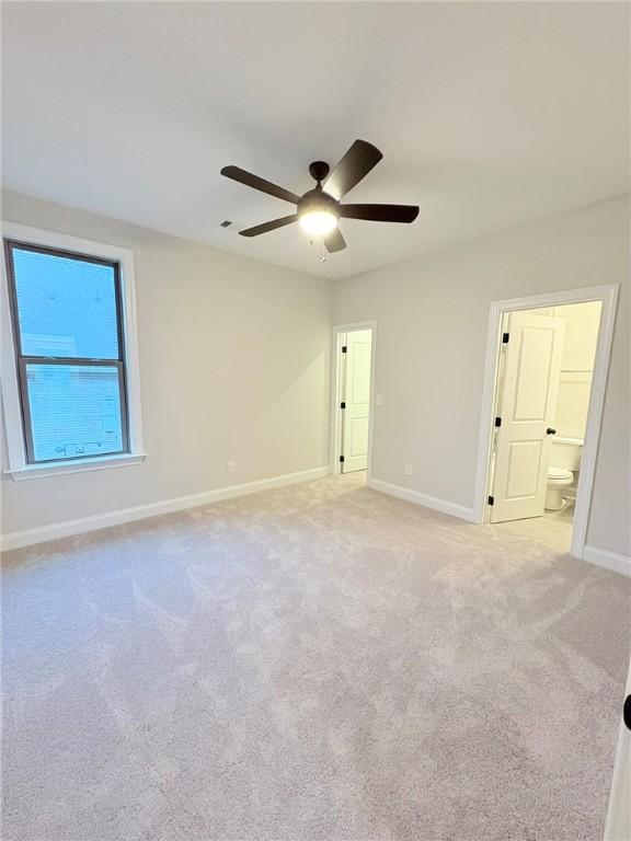 carpeted spare room with ceiling fan