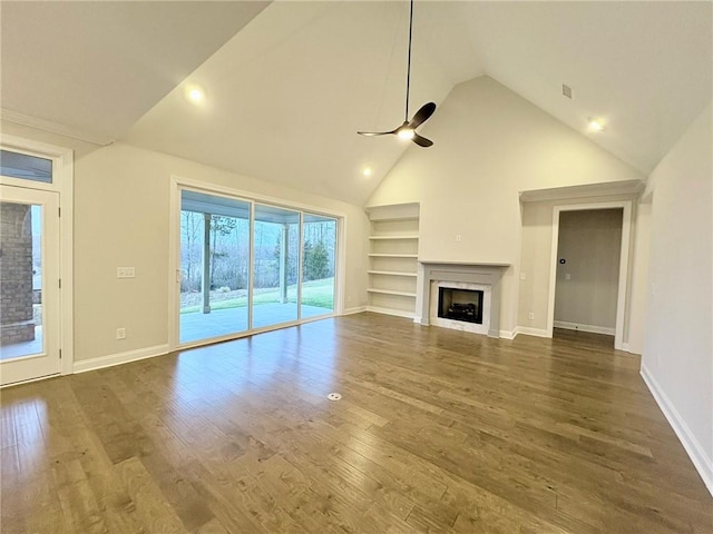 unfurnished living room with high vaulted ceiling, dark wood-type flooring, ceiling fan, and built in shelves